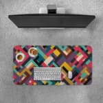 Infidu colorful geometric desk pad with bold blocks in red, teal, mustard, and maroon on a white background.