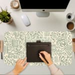 Infidu desk pad with light green abstract doodle design on cream background, featuring playful shapes, lines, and artistic elements.
