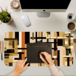 Infidu desk pad with earth-tone geometric blocks and layered abstract design on a white background