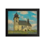 Vintage wall art of a rustic church in a calm countryside with a blue sky, white clouds, green grass, and touches of purple wildflowers. hung on the wall