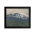 Infidu vintage wall art of snowy mountains in soft blue tones with a misty sky and forested valley. hung on the wall