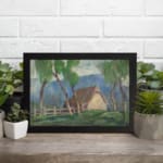 Vintage wall art of a countryside cottage with green trees and soft blue mountains. displayed on the wall