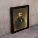 Vintage portrait wall art of a bearded man in a formal navy uniform with gold shoulder details and a smoky brown-gold background. displayed on the wall