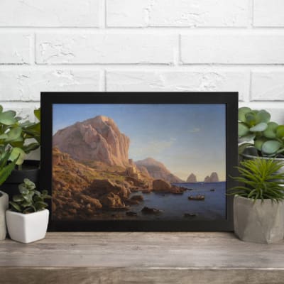 Vintage wall art featuring a peaceful boat scene with mountain views in soft blue, green, and earthy tones. Ideal for timeless decor. displayed on the table in a black frame