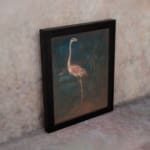Vintage wall art of a pink flamingo standing in a dark, natural setting with elegant contrast and tropical plants in the background. displayed on the wall