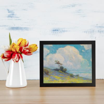 Infidu vintage wall art with blue sky, fluffy white cloud, green hill, and small trees in a peaceful outdoor landscape. displayed on the wall