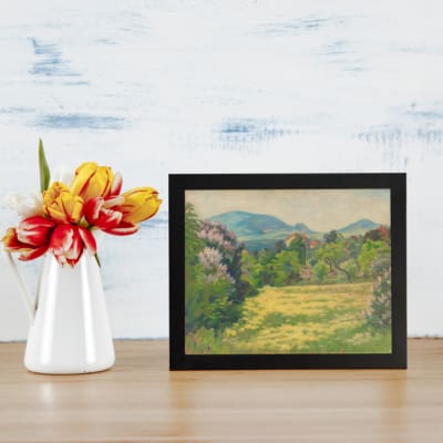 Vintage wall art featuring peaceful green fields, yellow flowers, and blue hills, creating a calming nature scene. displayed on the wall