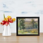 Vintage countryside wall art with yellow flower fields, tall green trees, and a soft cloudy sky in natural tones. displayed on the wall
