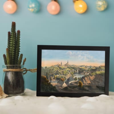 Infidu Classic Townscape with Rolling Hills Vintage Wall Art featuring a peaceful town view with green hills, a river, and church towers. displayed on the wall