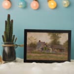 Vintage countryside wall art with rustic houses, tall trees, and soft earthy tones under a cloudy sky. displayed on the wall