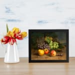 Vintage fruit still life wall art with grapes, apples, peaches, and plums on a rustic surface and dark leafy background. displayed on the wall