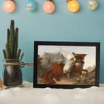 Vintage wall art of a red fox holding a bird in its mouth, set in a mountain landscape with rocky terrain and a pale blue sky. displayed on the wall