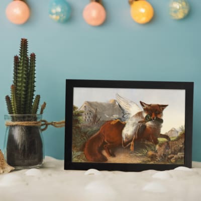 Vintage wall art of a red fox holding a bird in its mouth, set in a mountain landscape with rocky terrain and a pale blue sky. displayed on the wall