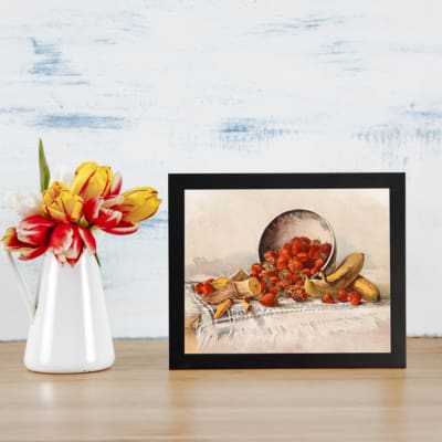 Vintage wall art featuring spilled strawberries and bananas, creating a warm and inviting atmosphere. displayed on the table in a black frame