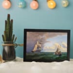 Vintage nautical wall art with two elegant sailboats on a deep green ocean under a dramatic sky. displayed on the wall