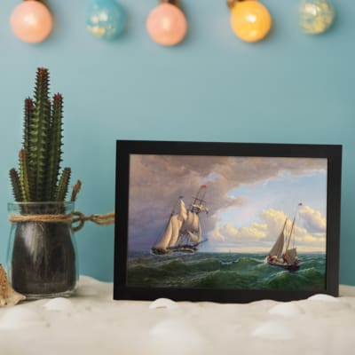Vintage nautical wall art with two elegant sailboats on a deep green ocean under a dramatic sky. displayed on the wall