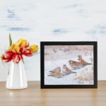 Snowy Birds Vintage Wall Art with small birds sitting on a snowy ground in soft winter tones, bringing a peaceful atmosphere. displayed on the wall
