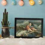 Infidu vintage wall art featuring a woman in period attire on a small boat amidst stormy seas with dramatic waves and a cloudy sky. displayed on the wall art in a black frame