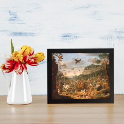 Vintage wall art featuring a lush forest, distant mountains, and birds flying in a serene valley, creating a warm nostalgic atmosphere. displayed on the table in a black frame