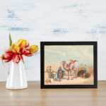 Vintage wall art featuring a camel with a rider, festival scene with colorful figures, and desert architecture in soft beige and blues. displayed on the wall