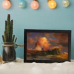 Vintage wall art of glowing red desert rocks with a vivid sunset sky and rugged terrain by Infidu. displayed on the wall