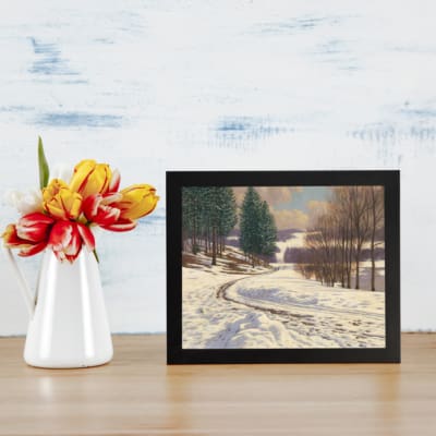 Vintage wall art of a snow-covered pathway with pine trees and a calm winter landscape, framed in black. displayed on the wall