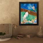 Vintage wall art of a white cow with brown spots in a colorful storybook-style field with flowers, a person, and a blue sky. displayed on the wall