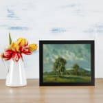 Vintage wall art of peaceful hills and soft clouds in natural green and blue tones. displayed on the wall