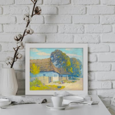 Vintage wall art featuring a peaceful rural house with a sloped roof, surrounded by trees and greenery, in soft, bright colors. displayed on the wall in a white frame