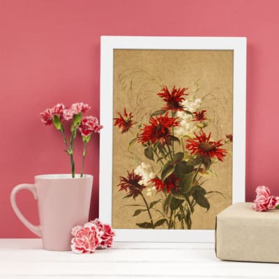 Elegant vintage wall art featuring a vibrant floral bouquet with red and white flowers, green leaves, and a classic muted background. displayed on the wall in a white frame on a pink background