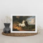 Vintage wall art of a white and dark brown horse in motion under a stormy sky with dramatic clouds and open fields. displayed on the wall