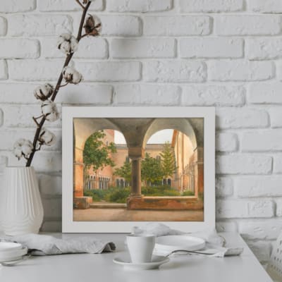 Infidu Vintage Wall Art featuring a serene courtyard with arched pathways and a lush garden, perfect for vintage home decor. displayed on the wall in a white frame
