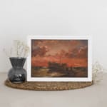 Vintage wall art of a wooden ship at sunset with fiery red, orange, and pink sky, calm sea, and small human figures near the shore. displayed on the wall