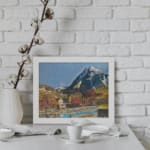 Vintage village at the base of snowy peaks with colorful houses, hills, and a serene river or pond. displayed on the wall