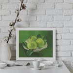 Infidu Vintage Green Apples in White Bowl Still Life Wall Art showcasing green apples in a white bowl with a soft green background. displayed on the wall