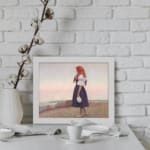 Vintage wall art of a woman on a grassy cliff overlooking the sea, wearing a red headscarf and holding a jug, in soft earthy tones. displayed on the wall