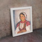 Vintage wall art of Eastern European woman in traditional red and white clothing with embroidered details. displayed on the wall
