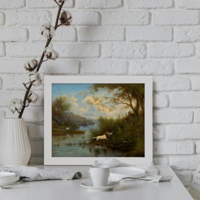 Infidu Serene Vintage Wall Art with River & Wildlife Design featuring a serene river, lush greenery, trees, and two animals with soft, natural colors in a classic style. displayed on the wall in a white frame