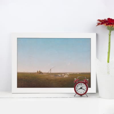 Vintage wall art showcasing a minimalist open field with earthy browns, greens, and a pale blue sky, framed in black for a modern finish. displayed on the wall in a white frame
