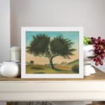 Vintage wall art of a lone tree in a peaceful landscape with soft green hills, distant hills, and a gentle blue and peach sky. displayed on the wall