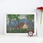 Vintage wall art of a countryside cottage with green trees and soft blue mountains. displayed on the wall