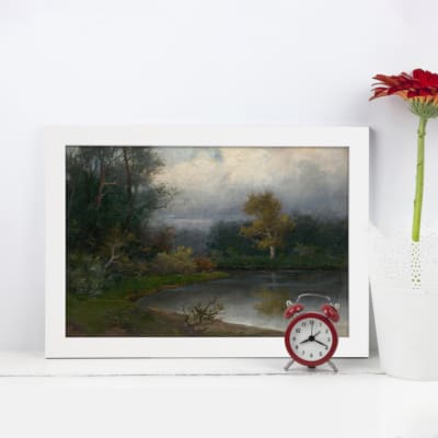 Vintage wall art showing a peaceful lakeside scene with trees, water reflections, and a soft green and blue color palette. displayed on the wall in a white frame