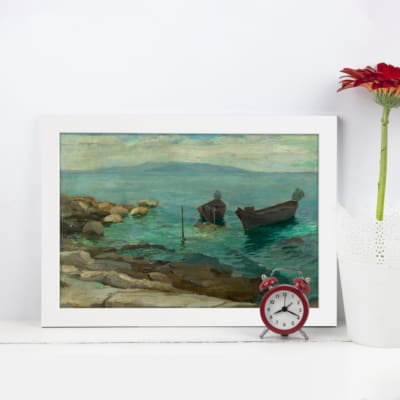 Vintage seaside wall art with calm blue water, rocky shoreline, small boats, and a seated figure evoking peaceful ocean vibesdisplayed on the wall in a white frame