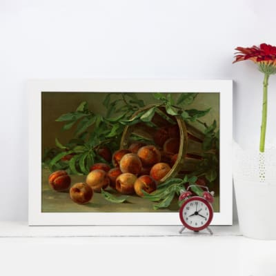 Vintage wall art featuring a basket of peaches with green leaves in a rustic still life design. displayed on the wall in a white frame