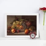 Rustic still-life painting of peaches, grapes, and pears in warm tones with a brown background and white frame. displayed on the wall