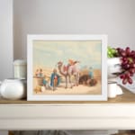 Vintage wall art featuring a camel with a rider, festival scene with colorful figures, and desert architecture in soft beige and blues. displayed on the wall