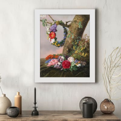 Vintage wall art featuring a tree trunk adorned with a colorful floral wreath and vibrant blooms in shades of orange, red, blue, and purple. hung on the wall in a white frame