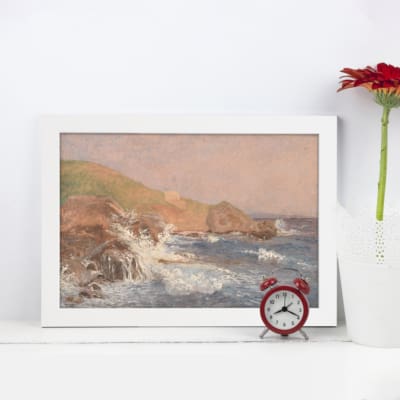 Serene coastal scene vintage wall art with waves, cliffs, and pastel sky for timeless beach-themed decor. displayed on the wall in a black frame