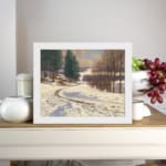 Vintage wall art of a snow-covered pathway with pine trees and a calm winter landscape, framed in white. displayed on the wall