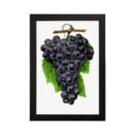 Vintage wall art print of dark purple grapes with green leaves on a white background. hung on the wall